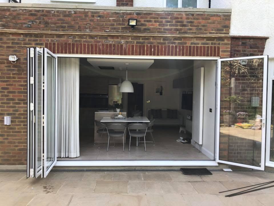 White uPVC bi-folding doors 3 panels open to garden patio